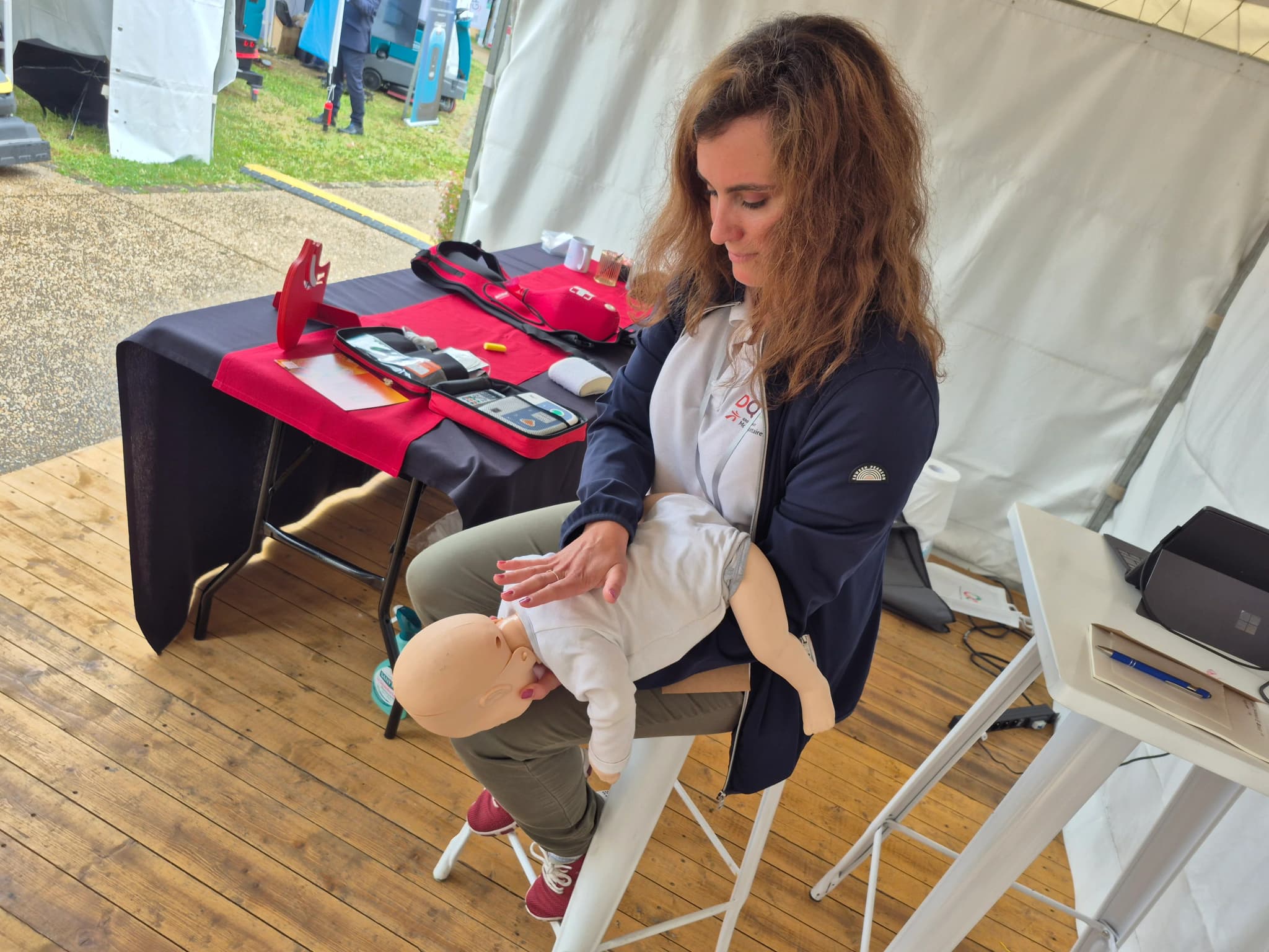 Participante installant un mannequin nourrisson sur ses genoux avant un geste de secours